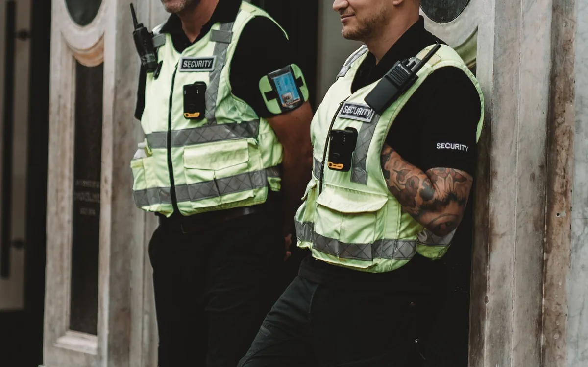 Securityprofessional gebruikt een portofoon tijdens toezicht.